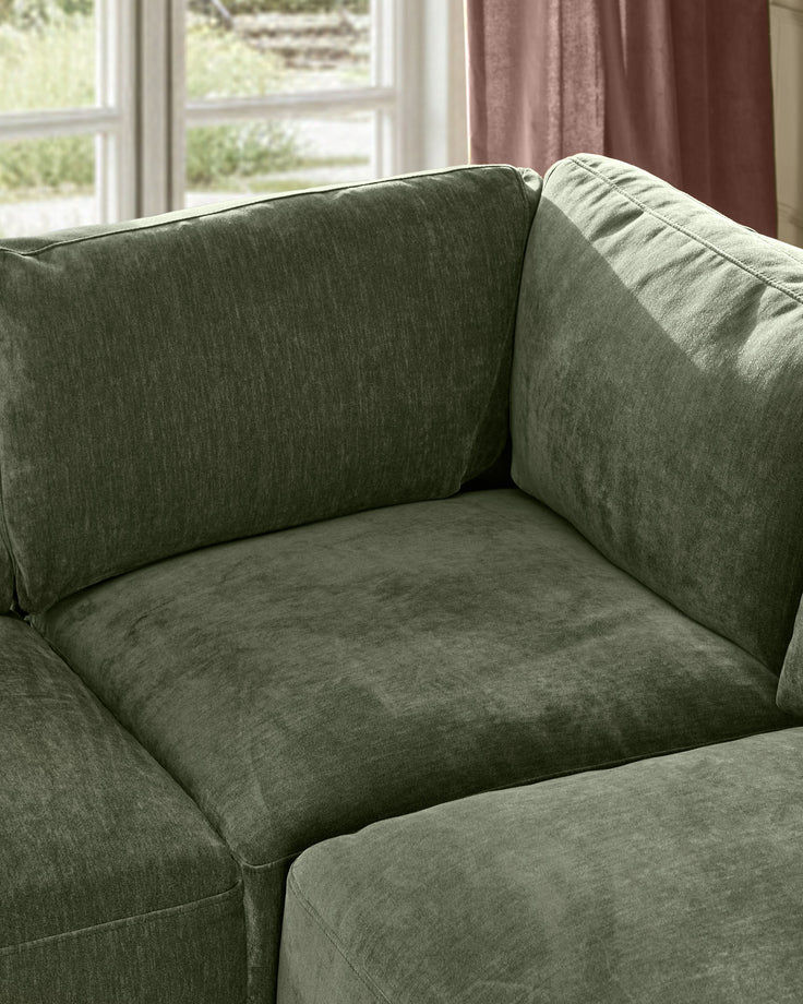 Eden 2-seater sofa in dark green fabric, shown at an angle displaying the seat cushion and upholstered arms.
