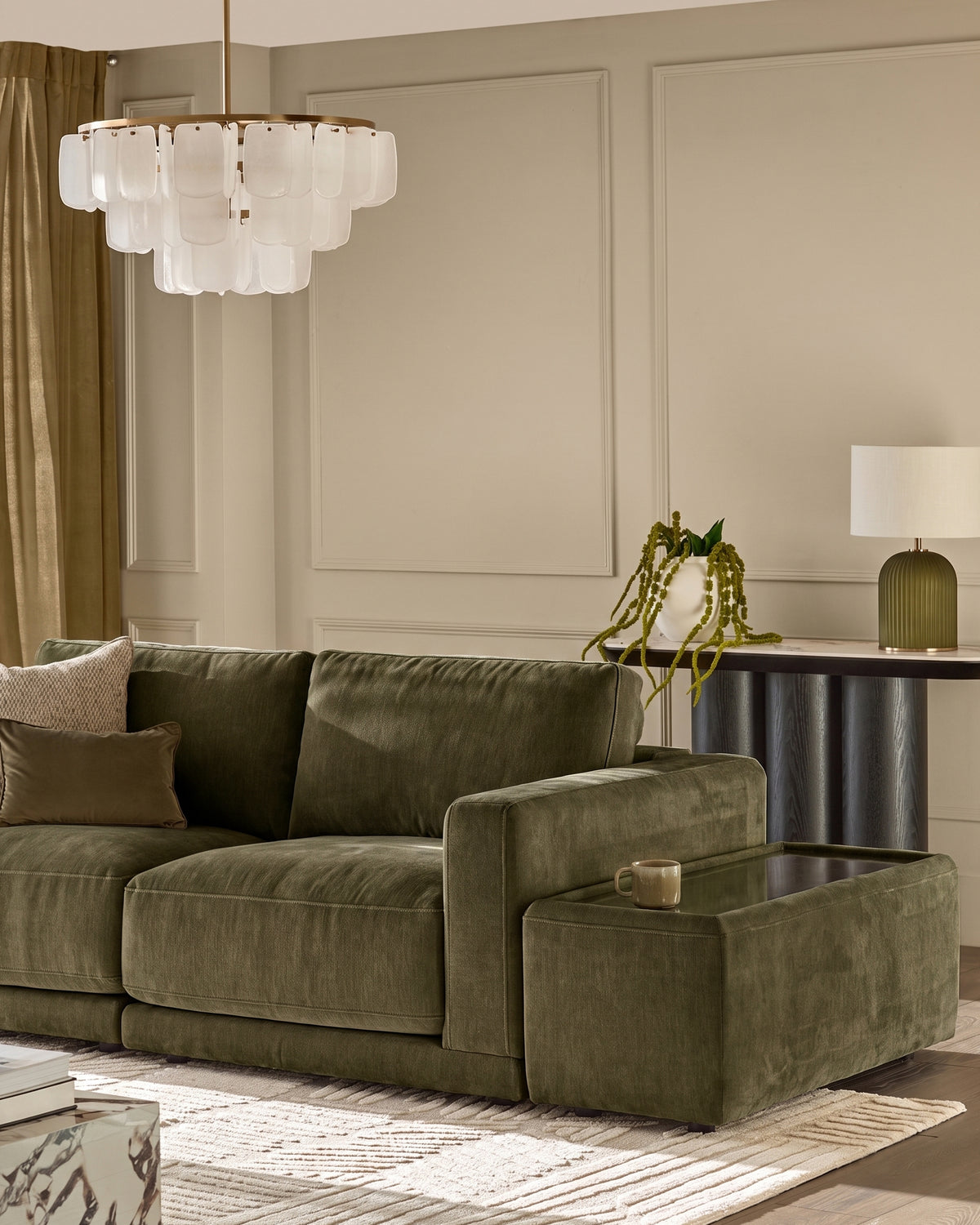 Eden side table module in dark green glass with fabric upholstery, positioned next to olive green sectional sofa in modern living room.