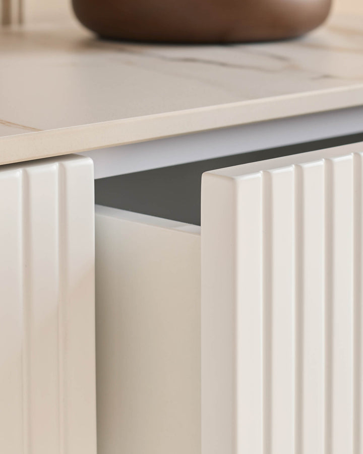 Edie Large Sideboard in natural ceramic with vertical fluted door detail and integrated handle, angled view.