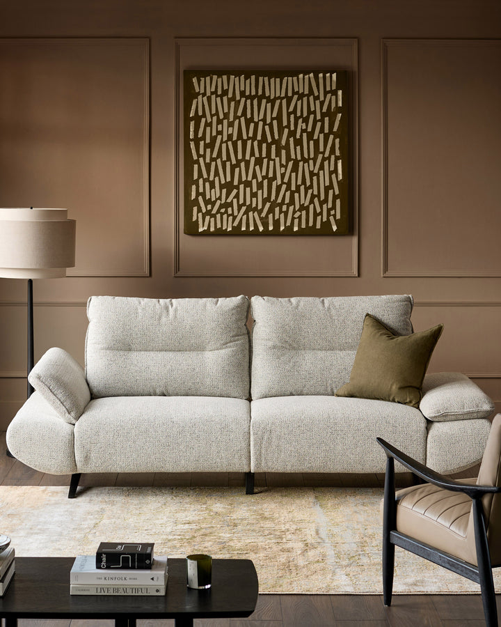 Elio 3-seater sofa in grey fabric with curved armrests and black legs, styled in a modern living room setting.