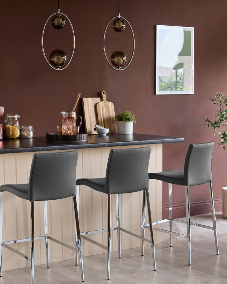 Elise faux leather bar stool in dark grey with chrome legs, shown at kitchen counter in modern dining space.