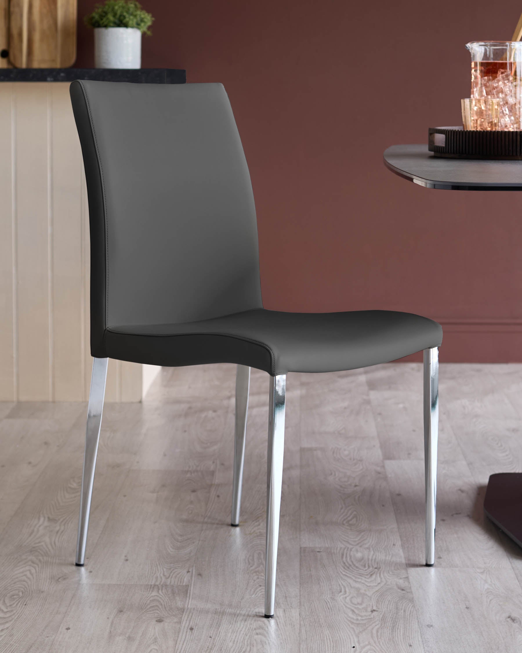 A stylish grey dining chair with sleek chrome legs adds a modern touch to any dining space.