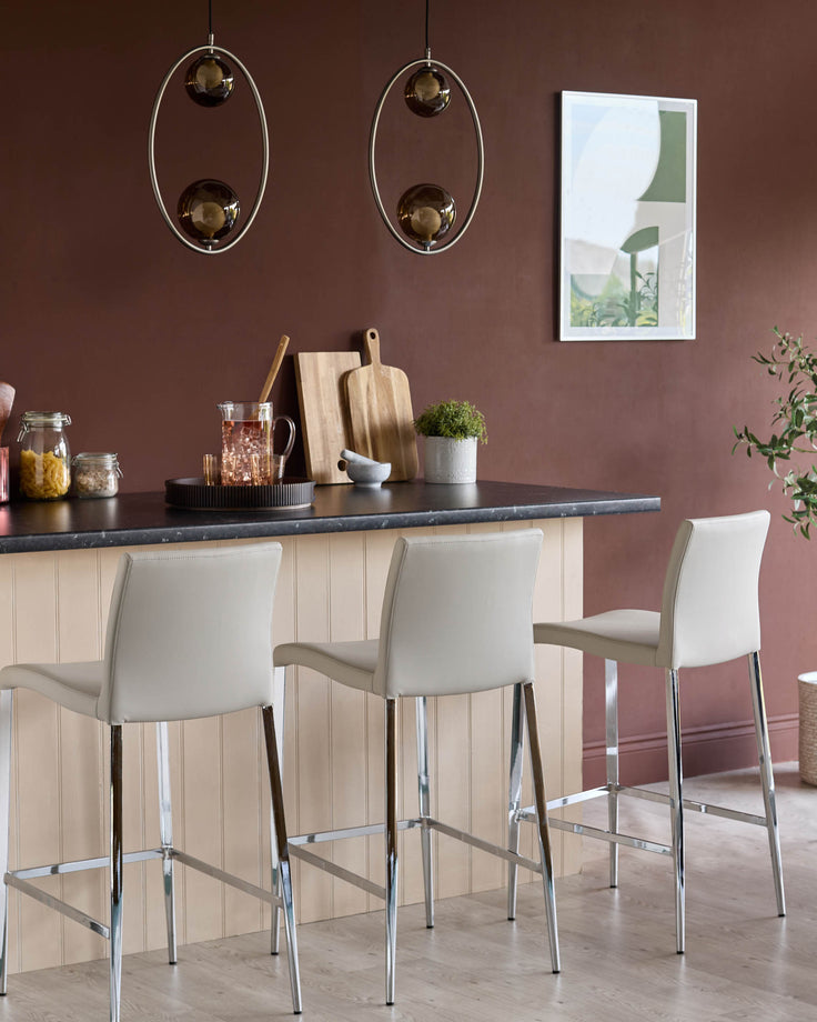Elise light grey faux leather bar stool with chrome legs, shown at kitchen island counter in modern dining setting.