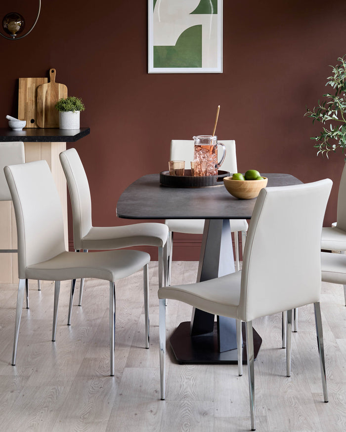 Dining set featuring a grey table and four stylish, light-coloured chairs with chrome legs, creating a modern dining space.