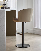 Elodie gas lift bar stool in mocha velvet and natural faux leather with black metal base, shown at an angle.