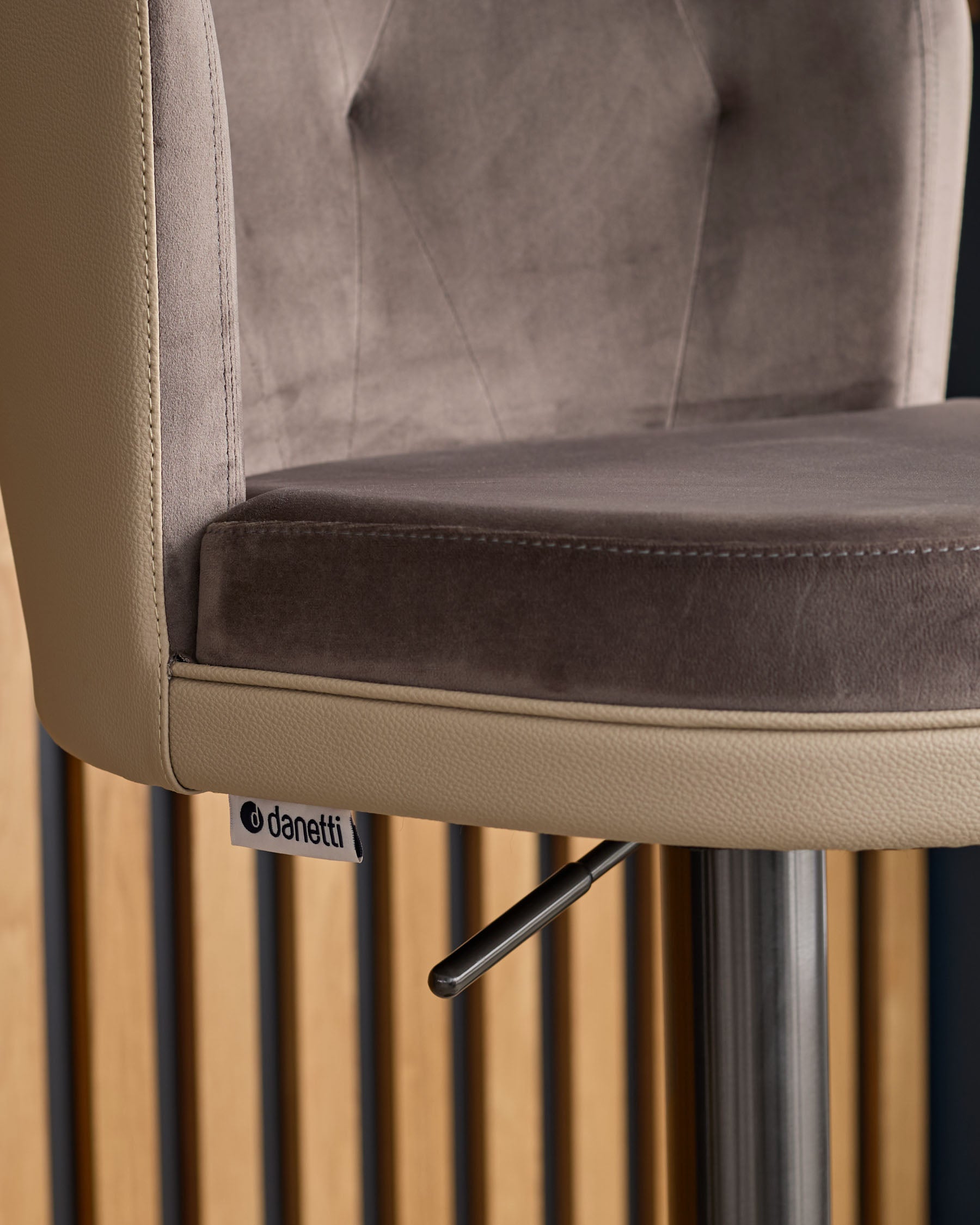 Elodie gas lift bar stool in mocha velvet and natural leather with chrome base, detail view of seat and leg mechanism.