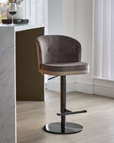 Elodie gas lift bar stool in mocha velvet with natural wood back and black metal base, shown in modern interior setting.