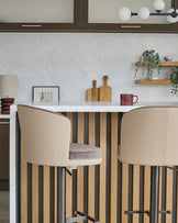 Elodie gas lift bar stool in mocha faux leather with natural wood striped base, shown at kitchen counter.