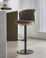 Elodie gas lift bar stool in mocha velvet with natural wood accents and black metal base, shown in modern kitchen setting.