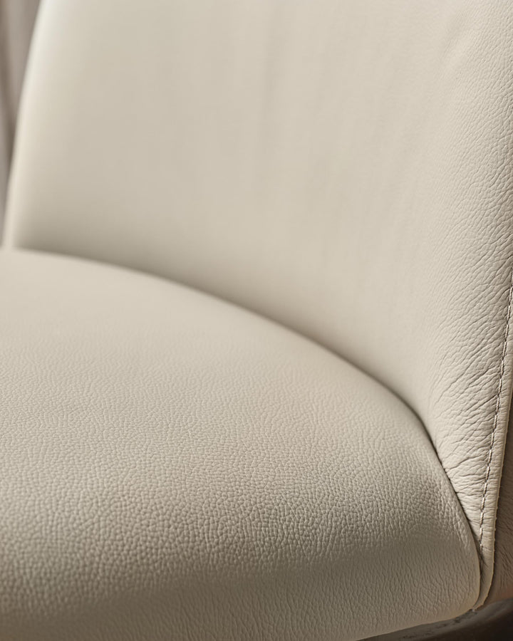 Close up of a beige leather chair showing the texture and seam.