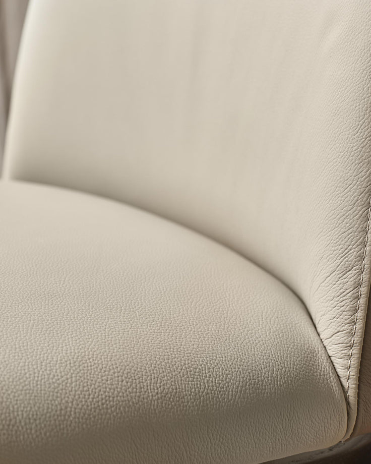 Close up of a beige leather chair showing the texture and seam.