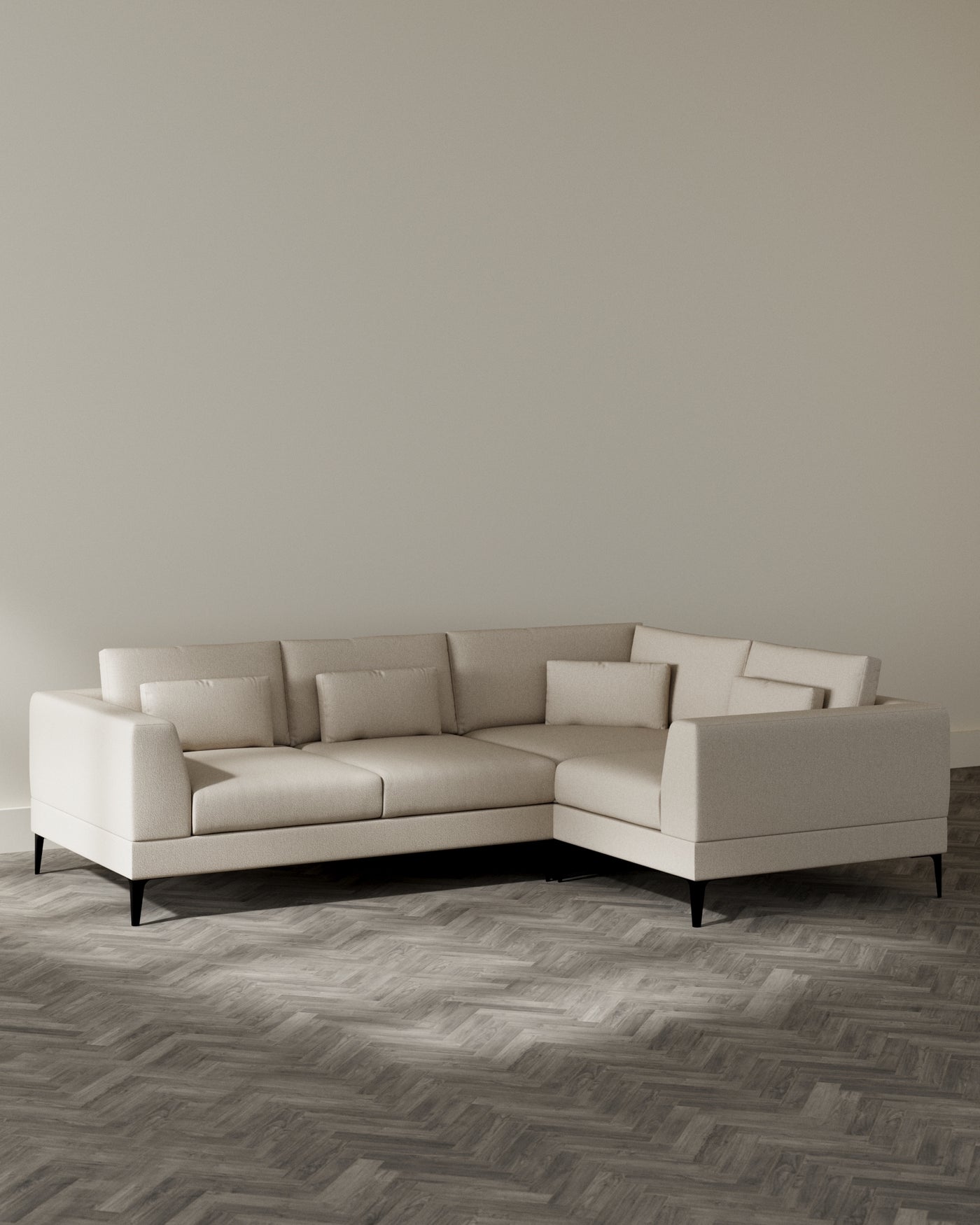 Elegant contemporary L-shaped sectional sofa with a clean-line design, featuring light beige upholstery and sleek black legs, set in a minimalist room with herringbone-patterned wooden flooring.