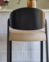 Enzo bar stool in natural leather with black curved backrest and metal frame, front view.