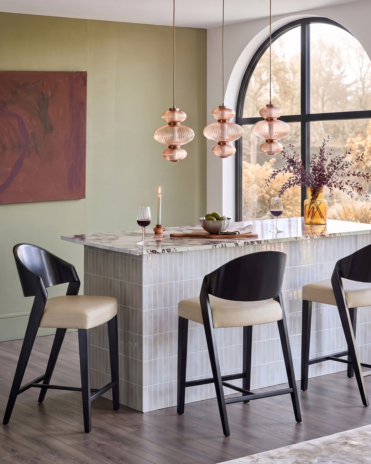 Enzo bar stool in natural leather with black wooden frame, shown at marble counter in modern dining space.