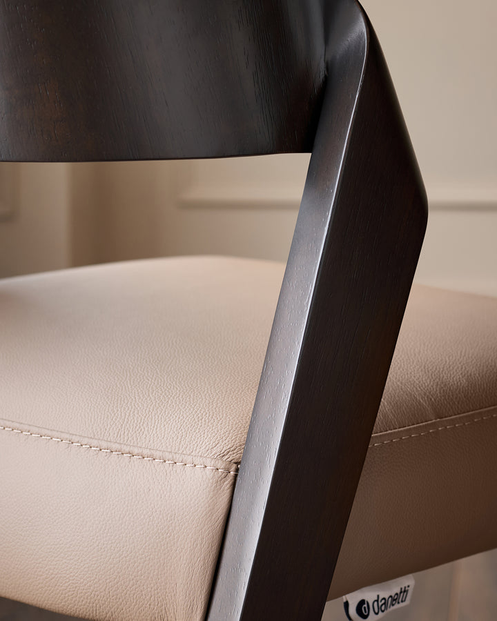 Enzo bar stool in mocha leather with dark wood frame, side detail showing stitching and sleek curved backrest.