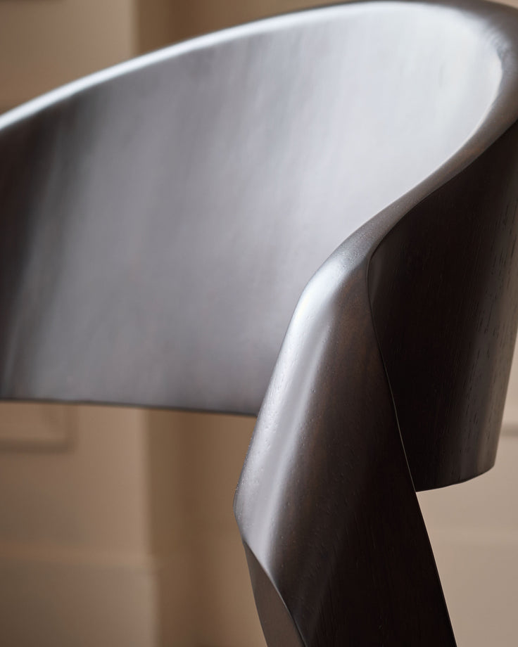 Enzo bar stool with mocha leather seat and dark wooden curved leg, shown in side profile detail.