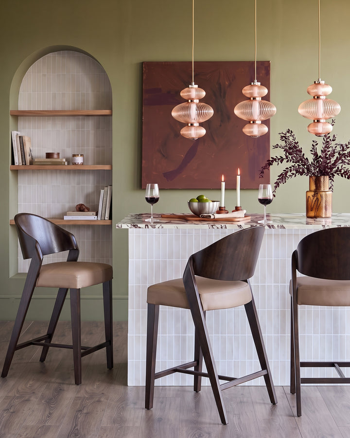 Enzo mocha leather bar stool with dark wood frame, shown at dining counter in modern interior setting.