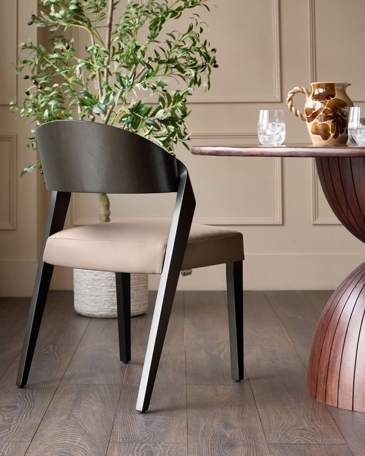 Enzo dining chair in mocha leather with black wooden legs, shown in a styled dining room setting.