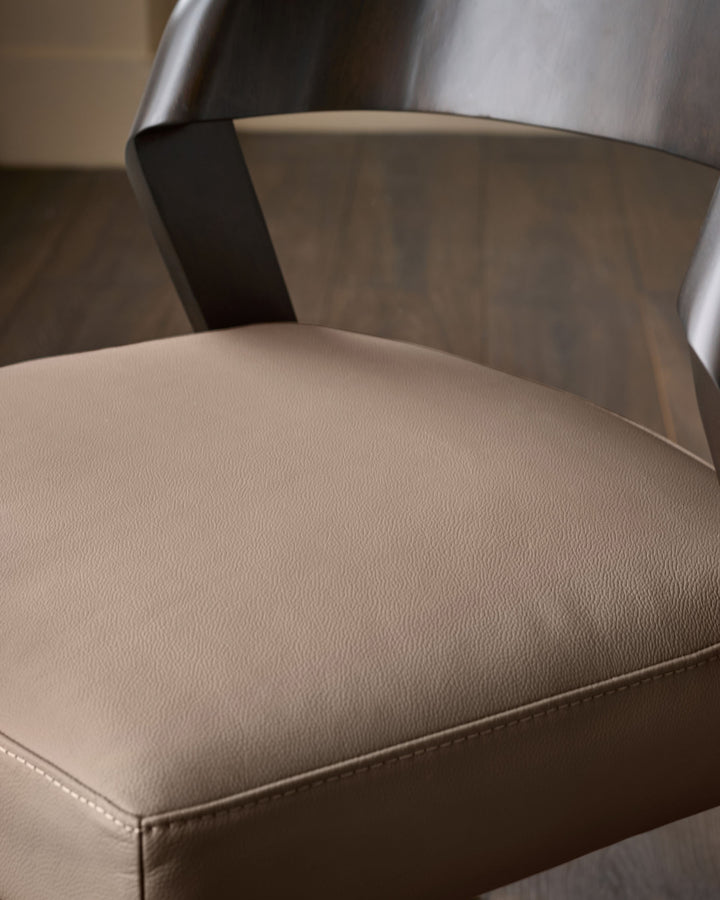 Enzo dining chair in mocha leather, showing curved backrest and upholstered seat detail from side angle.