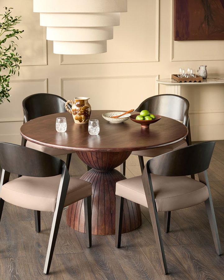 Enzo dining chair in mocha leather with curved black frame, shown at round wooden table in modern dining room setting.