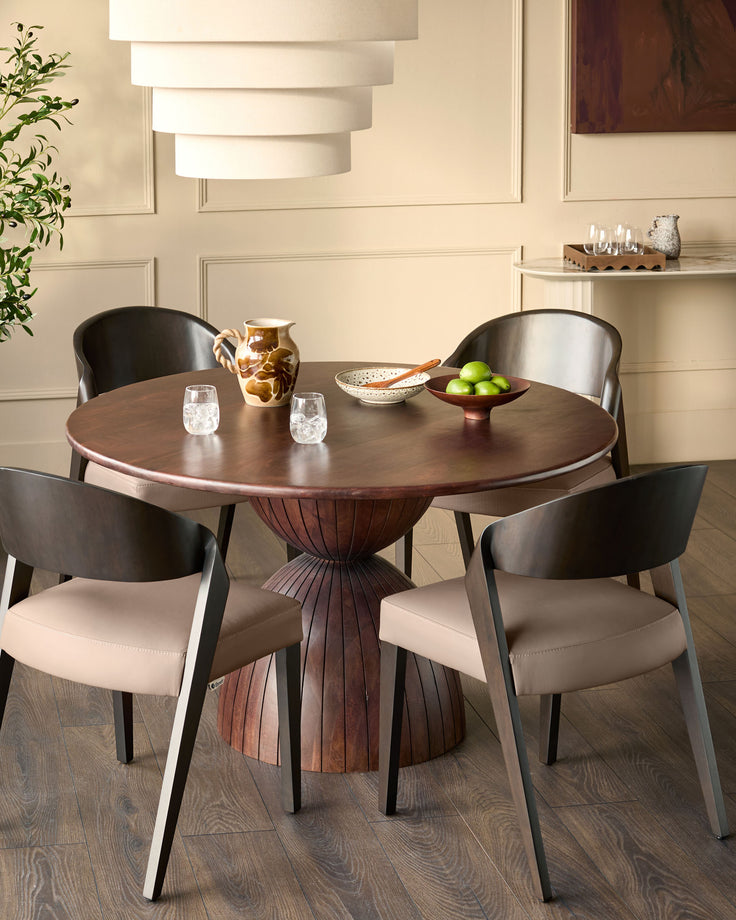 Enzo dining chair in mocha leather with curved black frame, shown at round wooden table in modern dining room setting.