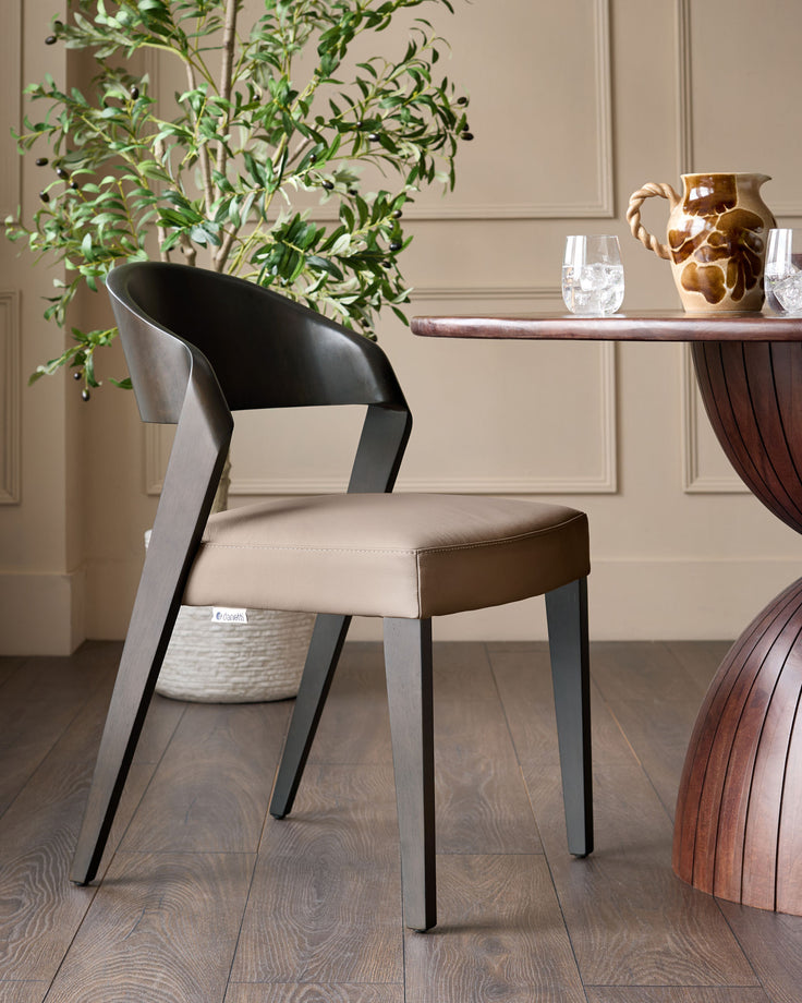 Enzo dining chair in mocha leather with curved black backrest and dark legs, shown in a styled dining room setting.
