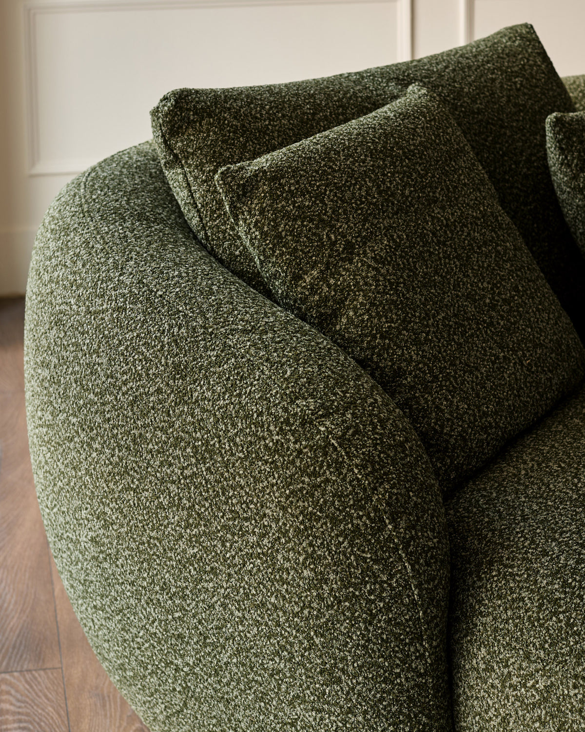 Dark green textured fabric left-hand corner chaise sofa with cushions, angled detail view