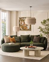 Dark green fabric left-hand corner chaise sofa with curved arms and plush cushions in a contemporary living room setting.