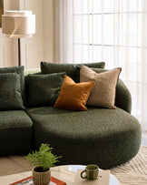 Dark green Eris right-hand corner chaise sofa with decorative pillows in a bright living room setting.