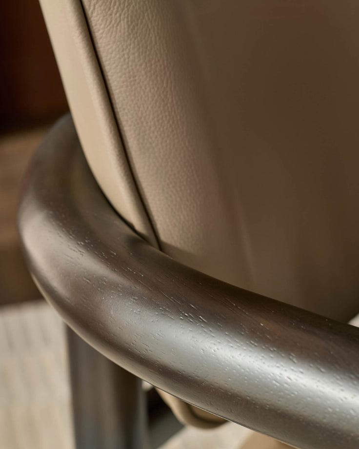 Esme dining chair detail showing mocha leather seat and brushed metal armrest