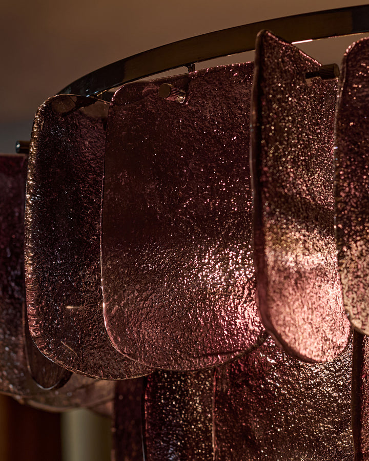 Smoked glass chandelier with ombre effect, rounded rectangular panels, metallic frame, backlit to showcase textured glass finish.