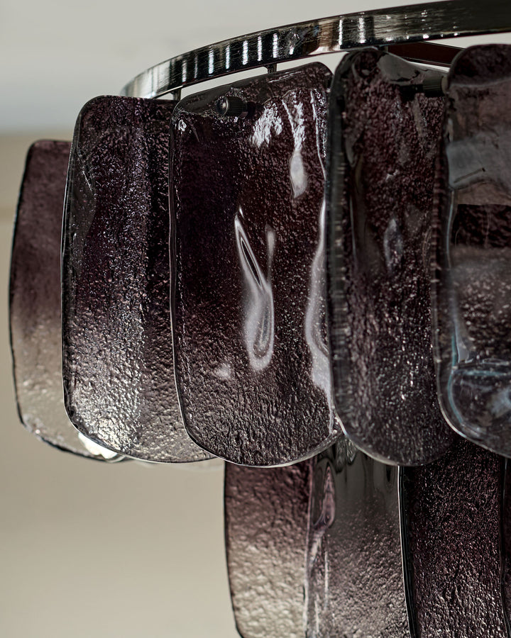 Smoked glass pendant shades on chrome rod, showing textured ombre finish and metallic detailing in close-up view.
