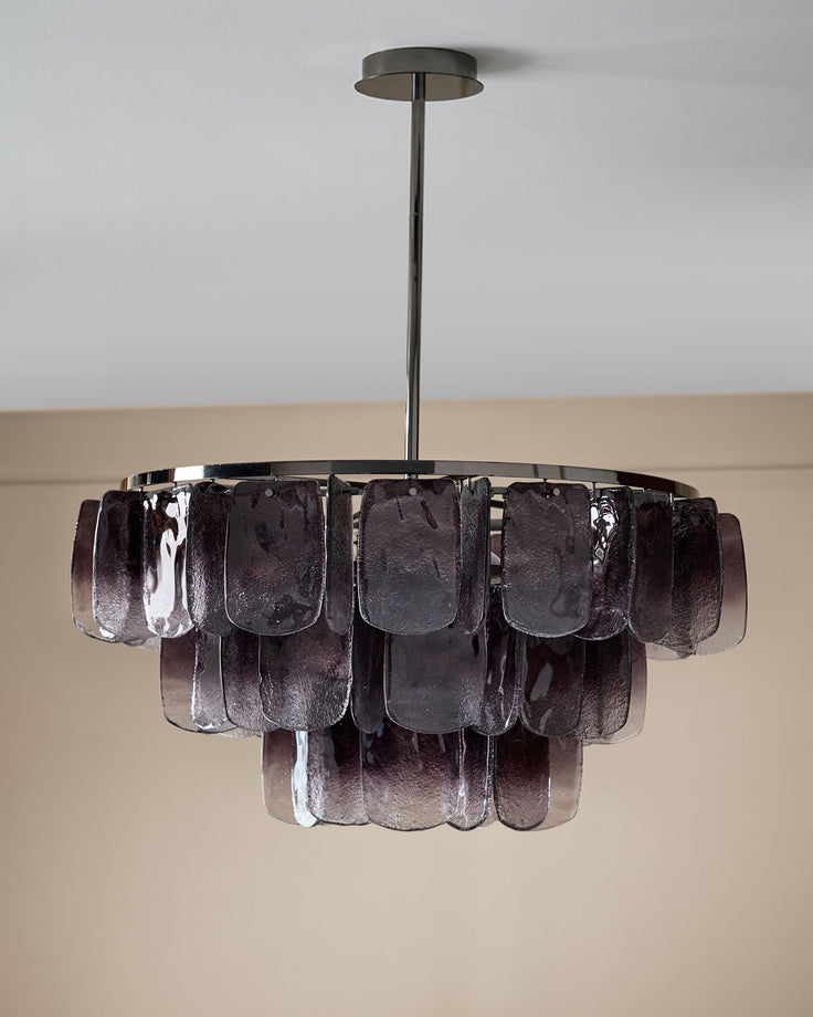 Estelle chandelier with smoked ombre glass panels suspended from chrome fixture against white wall.