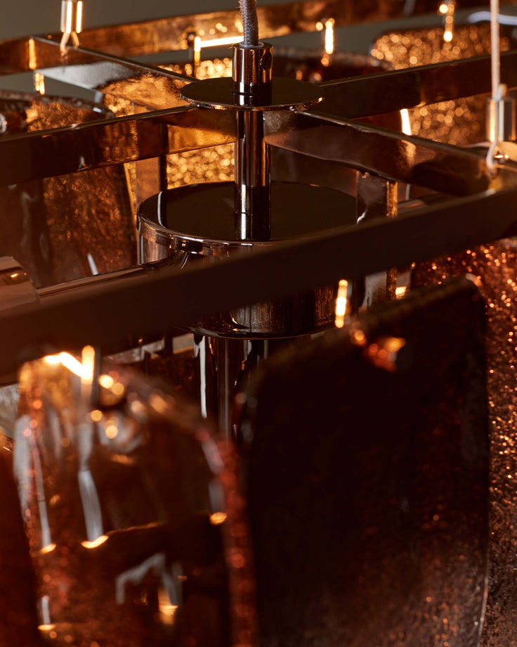 Close-up of a stylish, shiny bronze chandelier with a modern, geometric design. Statement lighting for a sophisticated interior.