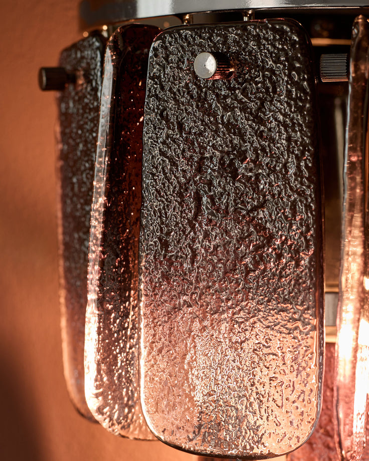 Estelle wall light with smoked ombre glass shade, rounded cylindrical shape, textured surface, chrome hardware, side view.