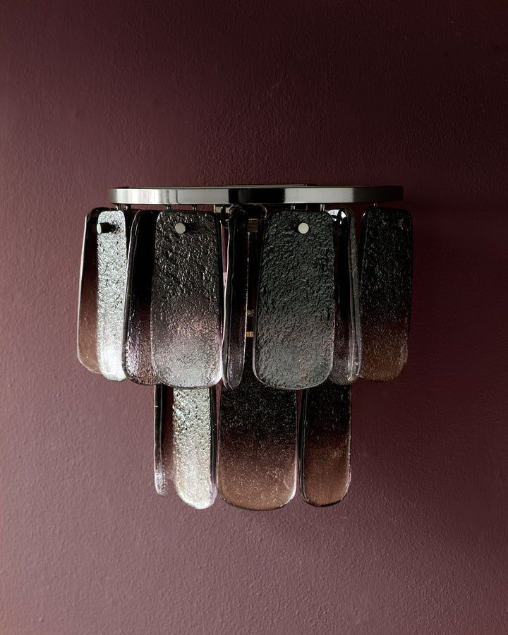 Estelle wall light with smoked ombre glass panels and chrome fixture against mauve background.