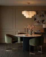 Dakota dining chair in olive green velvet with brass frame, shown in elegant dining room setting.