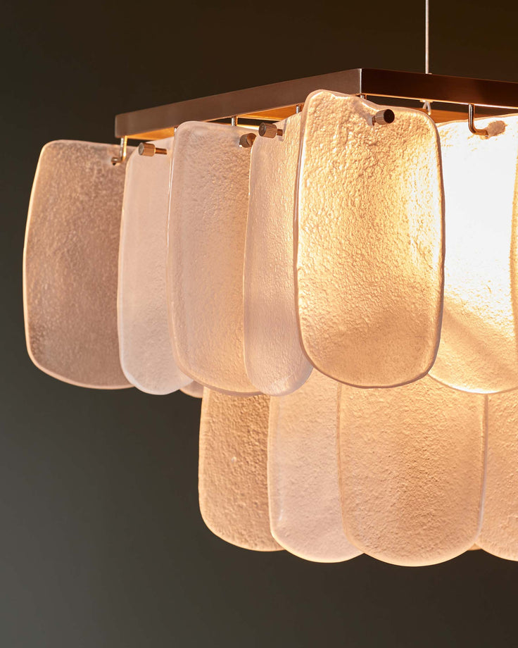 Stylish chandelier featuring textured glass panels suspended from a sleek, modern frame. Illuminates with a warm, inviting glow.