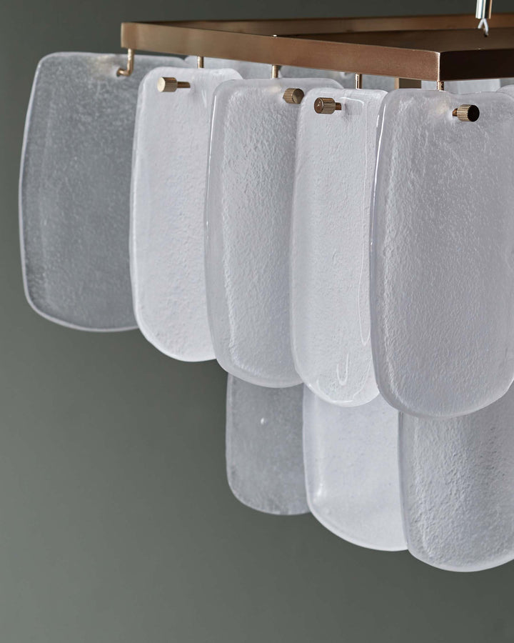 Stylish light fixture with frosted glass panels suspended from a bronze frame, creating a sophisticated cascade effect.