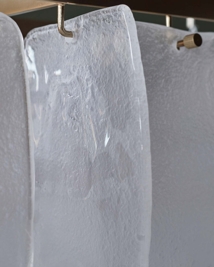 Close up of textured glass panels suspended from a metal fixture. Modern design lighting for a contemporary interior.