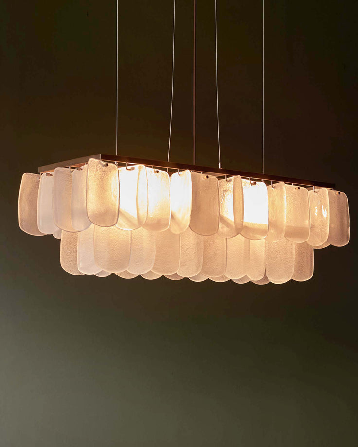 A stylish, modern chandelier with decorative glass pendants, suspended by thin cables from a rectangular frame.