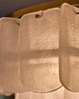 Estelle chandelier with white textured glass shades and brass hardware, close-up detail view.