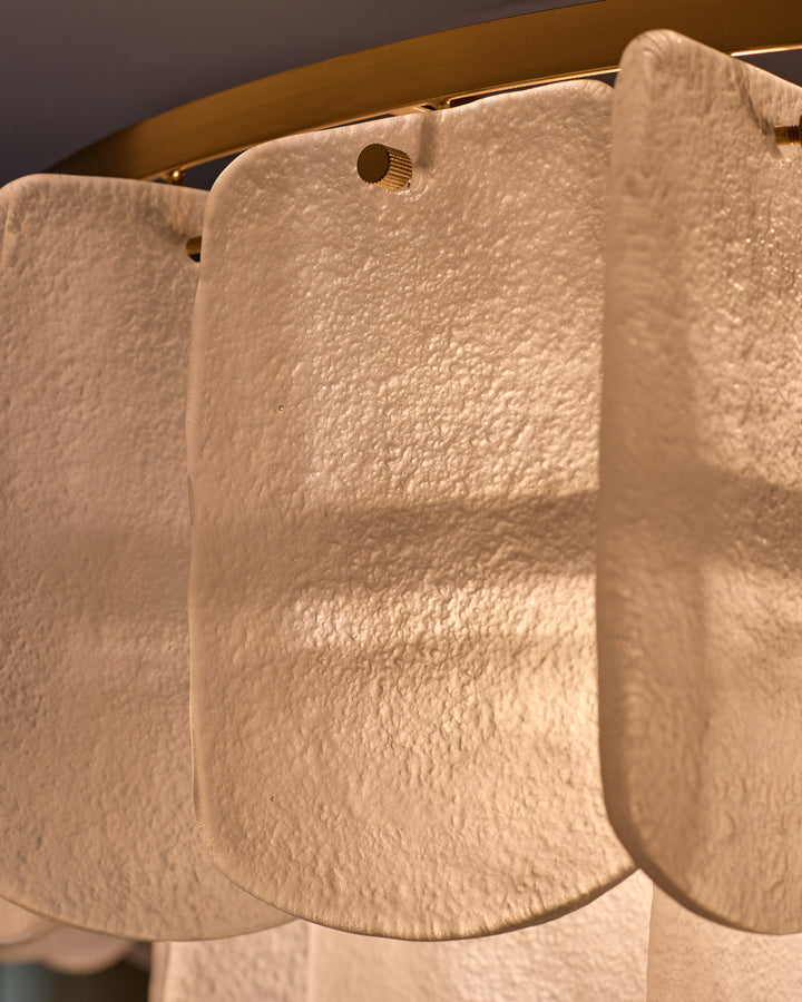Estelle chandelier with white textured glass shades and brass hardware, close-up detail view.
