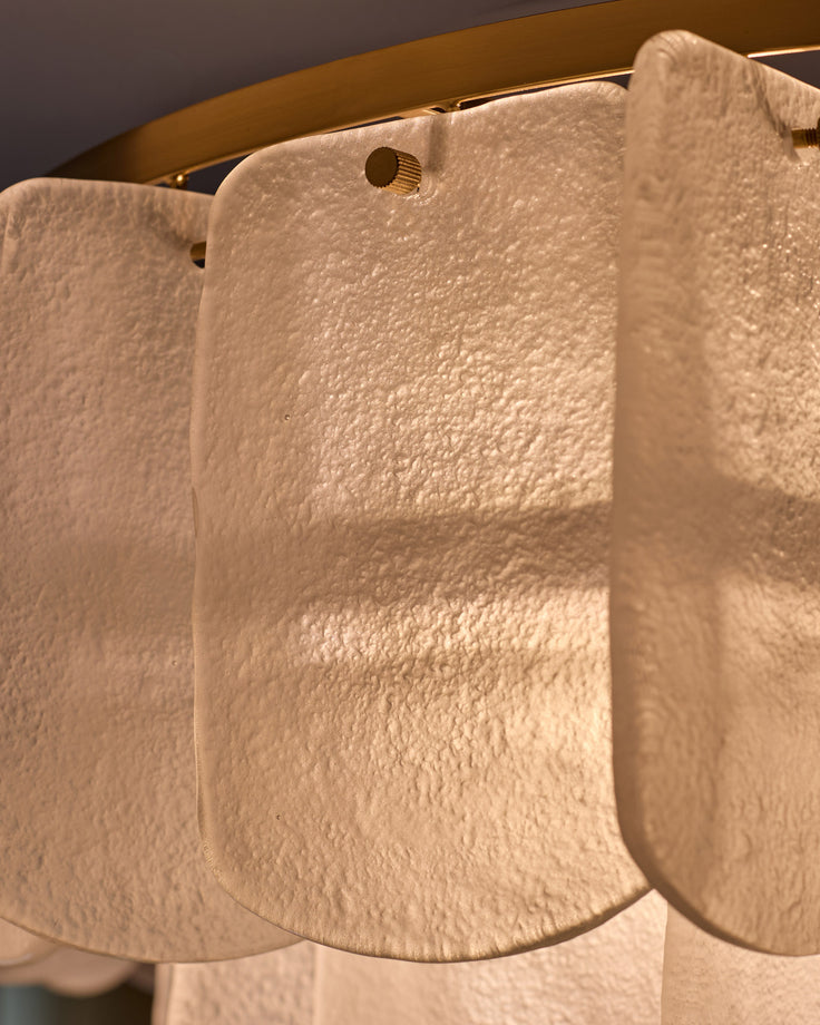 Estelle chandelier with white textured glass shades and brass hardware, close-up detail view.