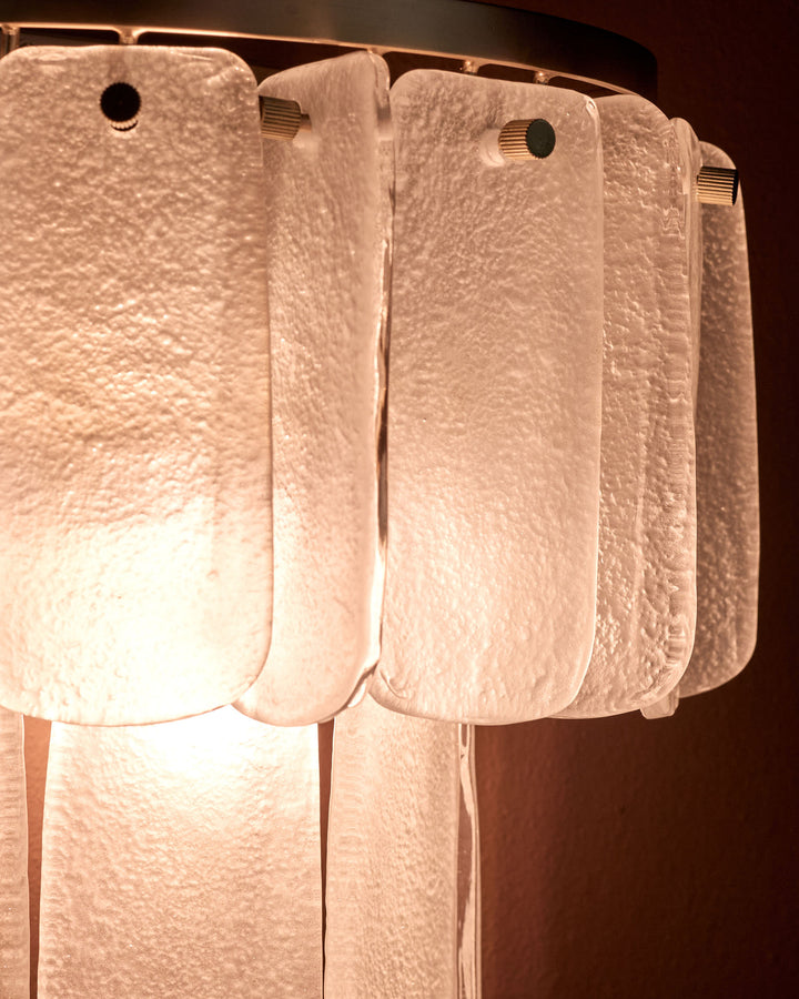 Estelle wall light with white textured glass shades hanging from metal fixtures against dark wall