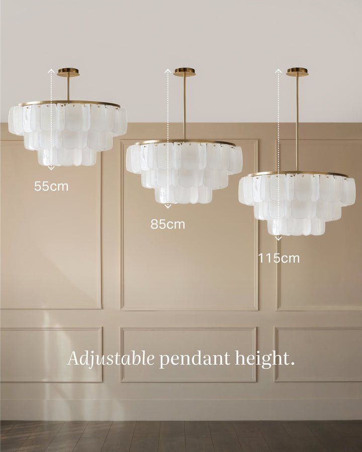 Estelle chandelier in brushed brass and white glass, shown in three adjustable height options ranging from 55cm to 115cm.