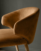 Ethan bar stool in caramel fabric, side view showing curved backrest and wooden legs.
