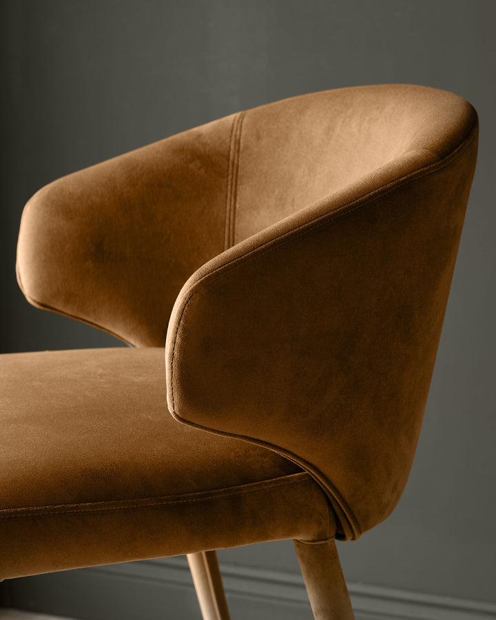 Ethan bar stool in caramel fabric, side view showing curved backrest and wooden legs.