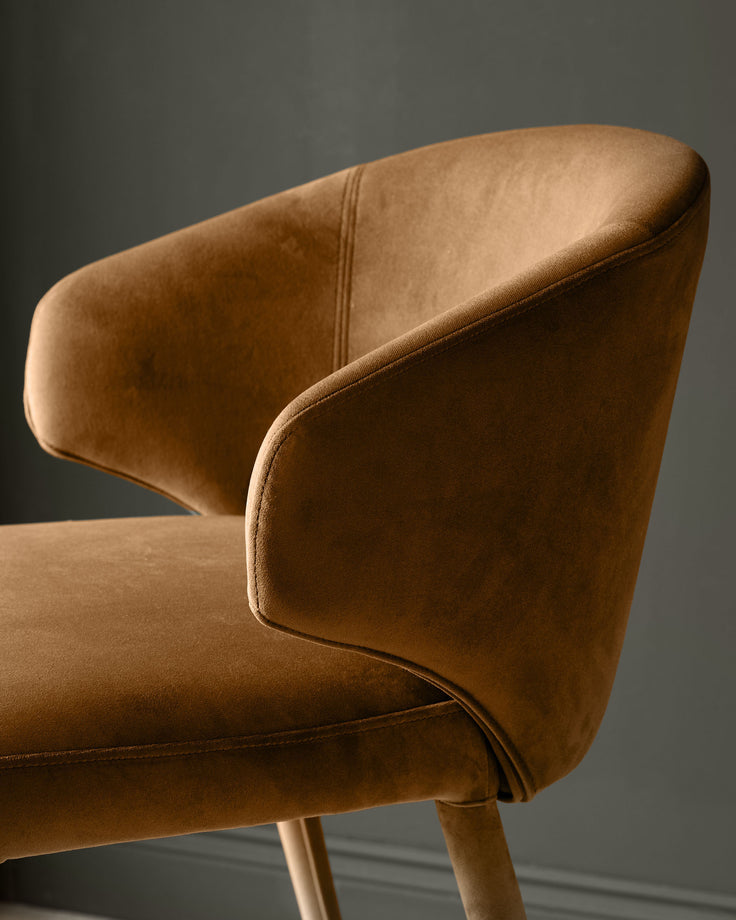 Ethan bar stool in caramel fabric, side view showing curved backrest and wooden legs.