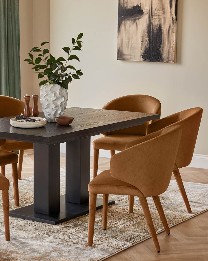 A modern dining set featuring a dark wood table and four ochre-coloured upholstered chairs on a textured rug.
